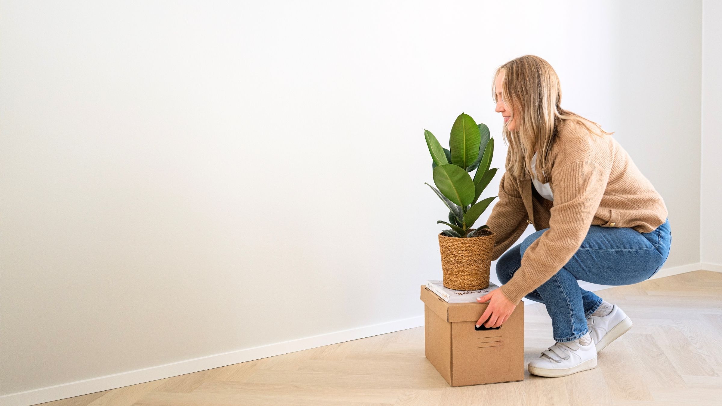 A person is putting a carboard box on the floor