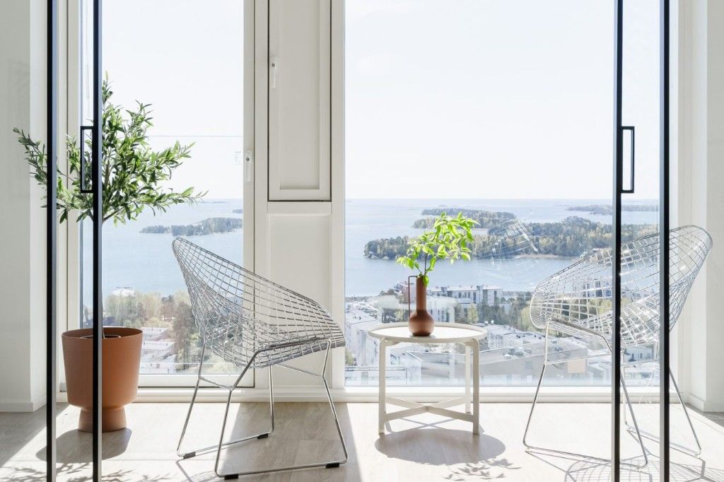 Design-tuolit ja merinäköala lattiasta kattoon ulottuvista ikkunoista.