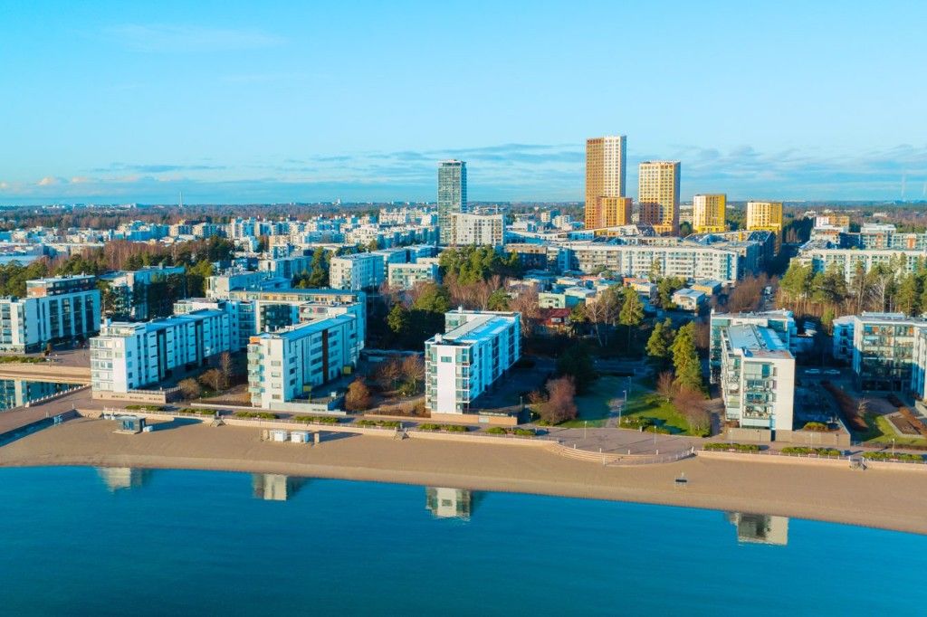 Aurinkolahti ilmasta: ranta, valkoiset kerrostalot ja tornitalot meren äärellä.